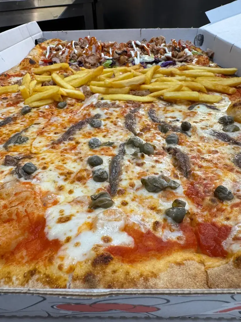 Pizza grande con gusti assortiti, kebab e patatine